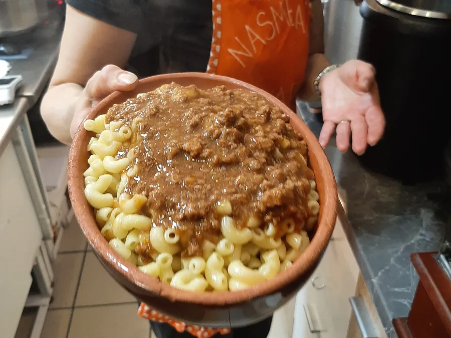 Kuharica drži veliko skledo makaronflajša